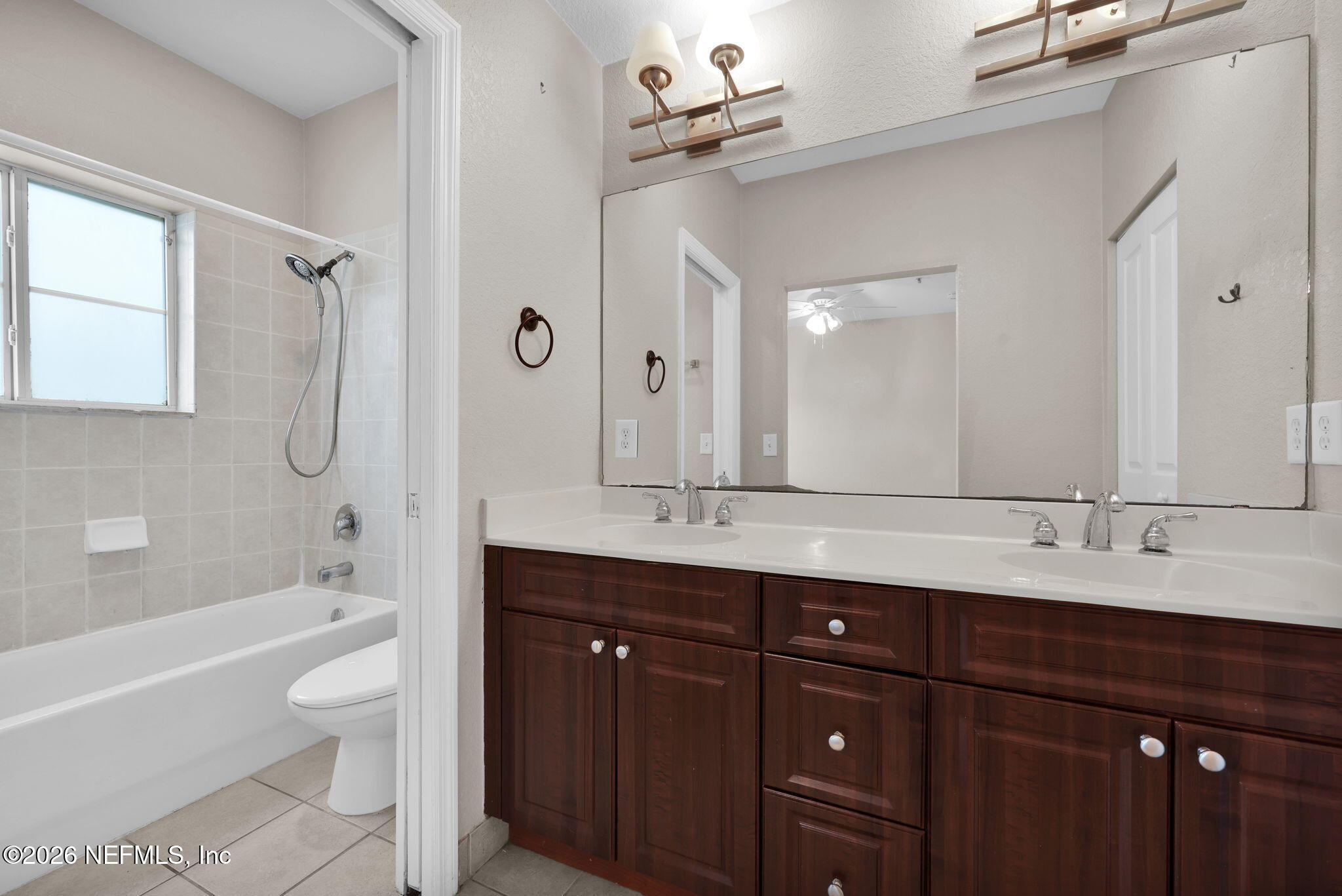 9745 Touchton Road, Unit 526 Jacksonville, FL 32246 - Photo 25 of 34 a bathroom with a double vanity sink toilet mirror and bathtub