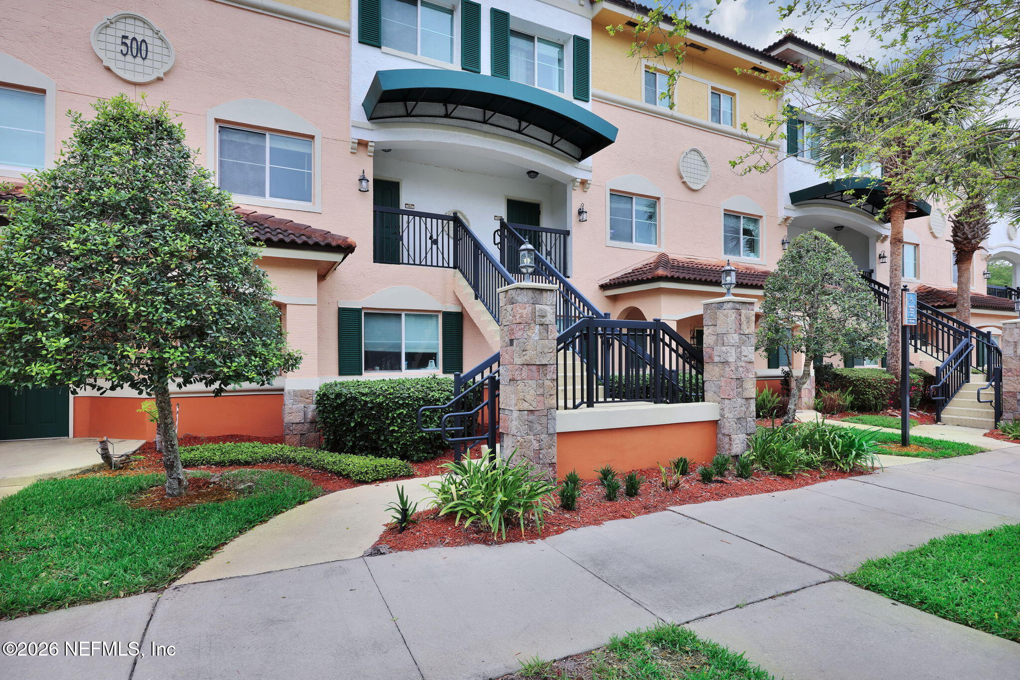9745 Touchton Road, Unit 526 Jacksonville, FL 32246 - Photo 5 of 34 a front view of a house with a yard and potted plants