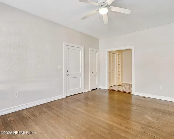 a view of an empty room with wooden floor