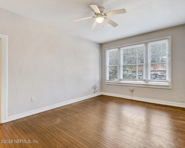 wooden floor in an empty room with a window