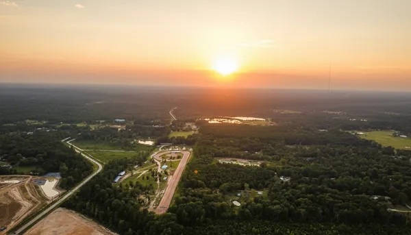 an aerial view of a residential houses with yard