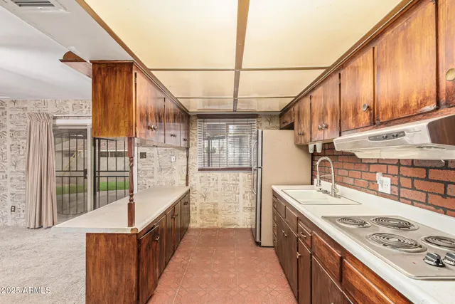 a kitchen with stainless steel appliances wooden cabinets a sink and a refrigerator