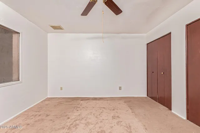 a view of a livingroom with a ceiling fan & entryway