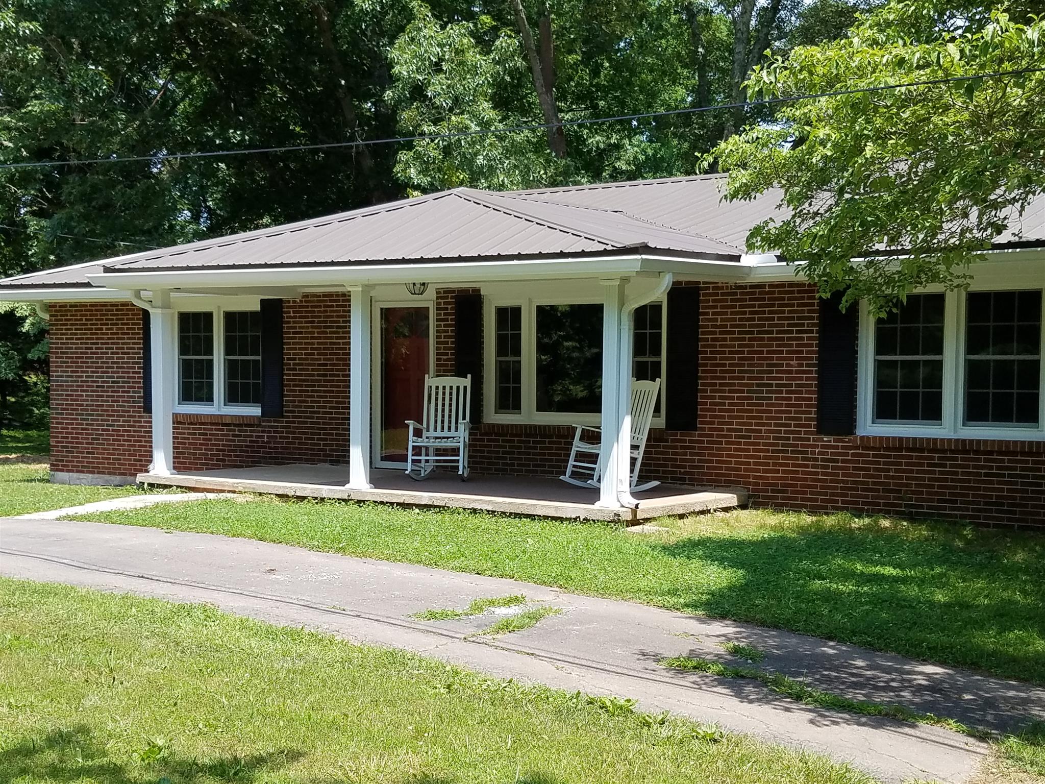 480 Eno Road Dickson, TN 37055 - Photo 1 of 14 a view of a brick house with a large windows plants and large trees
