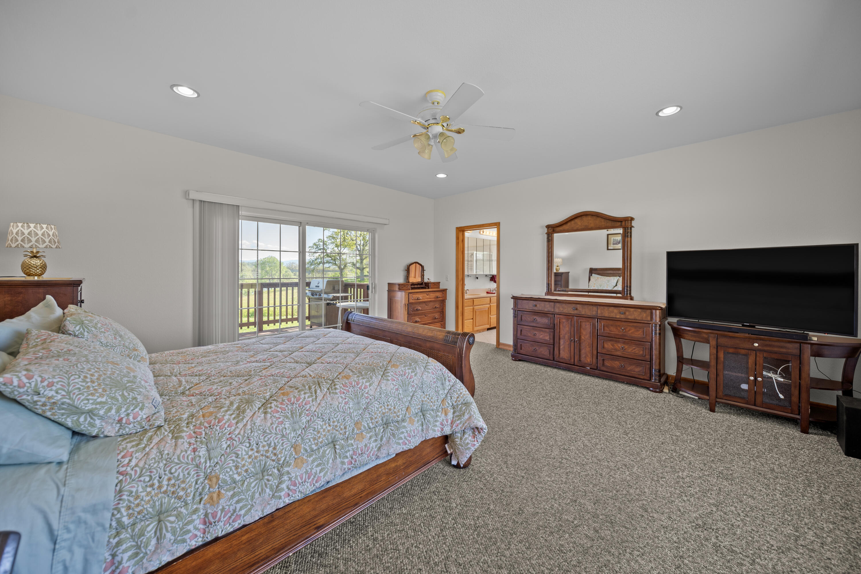 17935 Rivers Edge Drive Red Bluff, CA 96080 - Photo 18 of 38 a spacious bedroom with a bed and a flat screen tv