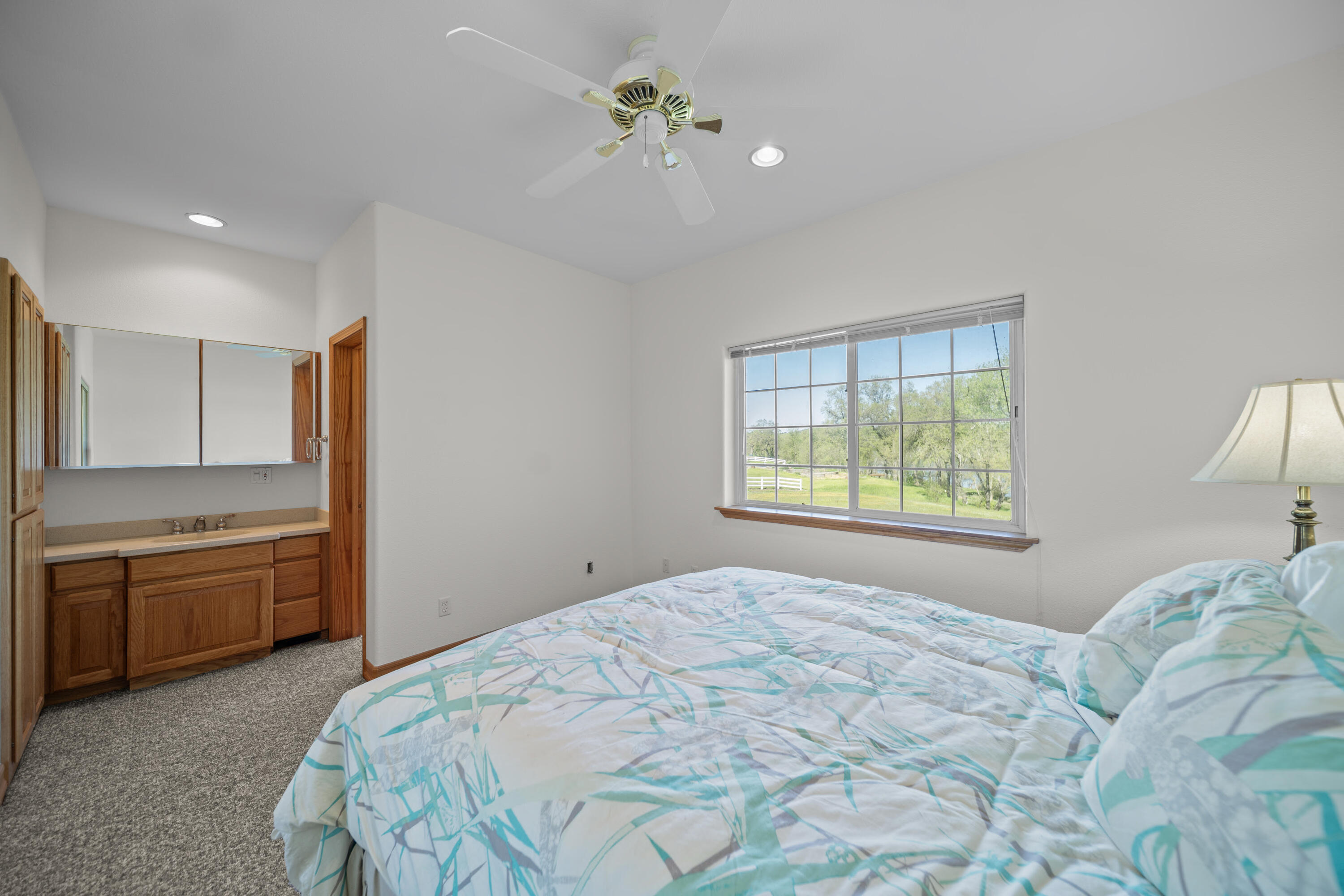 17935 Rivers Edge Drive Red Bluff, CA 96080 - Photo 26 of 38 a bedroom with a large bed and a chandelier