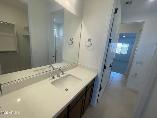 a spacious bathroom with a tub sink and mirror