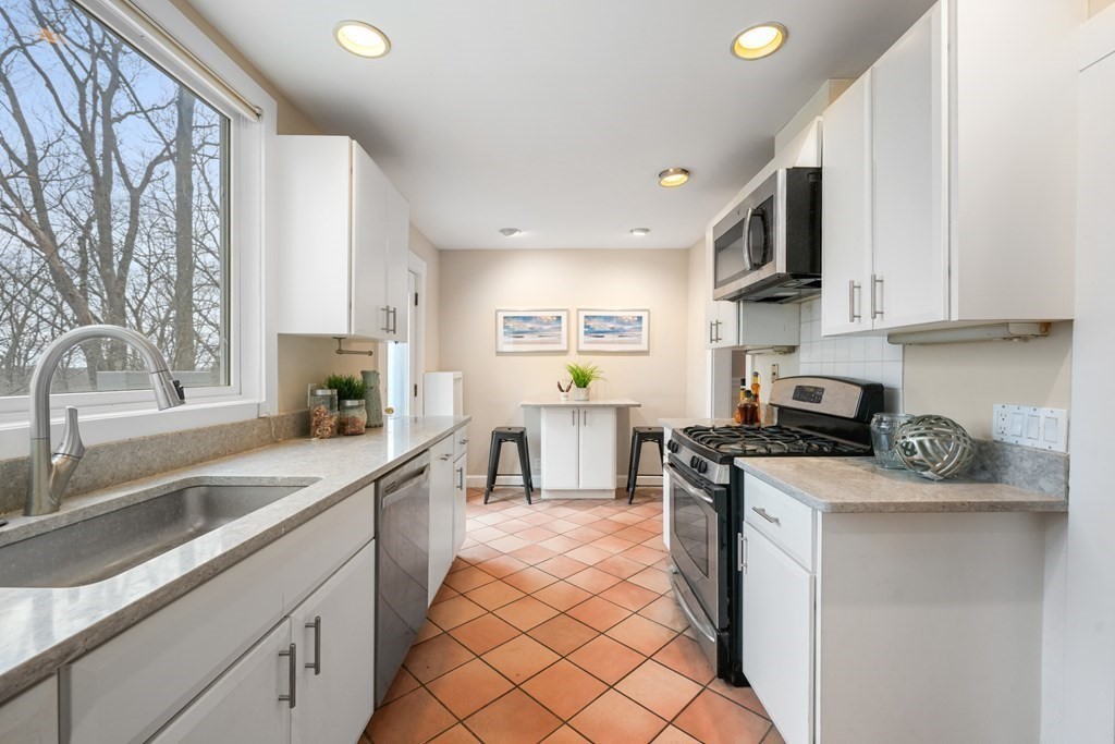93 Wolcott Road Brookline, MA 02467 - Photo 10 of 41 a kitchen with stainless steel appliances granite countertop a sink stove and cabinets