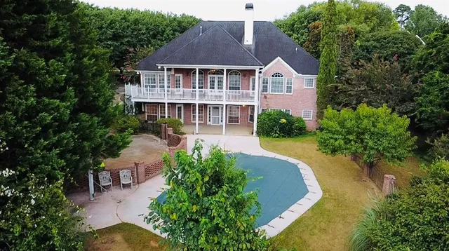 an aerial view of a house with swimming pool and porch