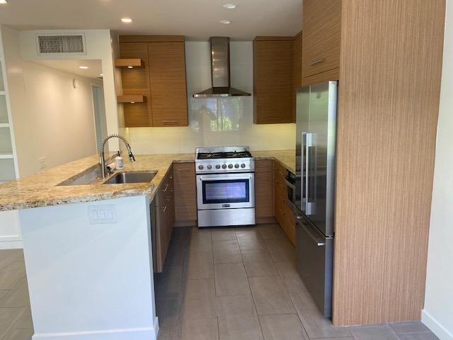 1111 East Ramon Road, Unit 10 Palm Springs, CA 92264 - Photo 3 of 23 a kitchen with stainless steel appliances granite countertop a stove a refrigerator and a sink