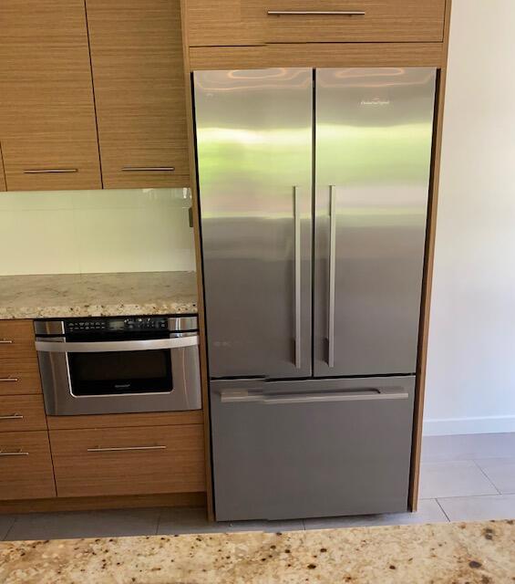 1111 East Ramon Road, Unit 10 Palm Springs, CA 92264 - Photo 9 of 23 a kitchen with a refrigerator and cabinets