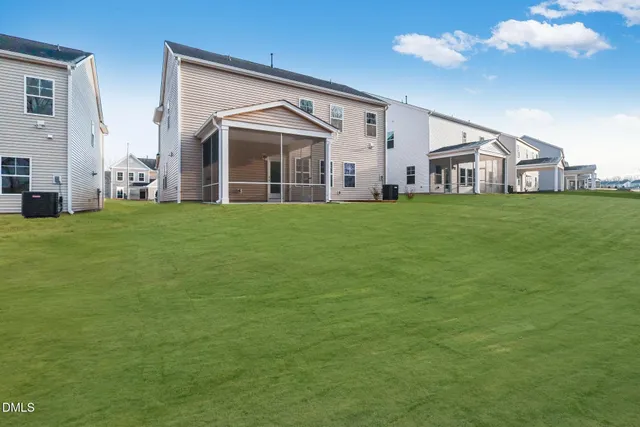 a view of a big house with a big yard and large trees