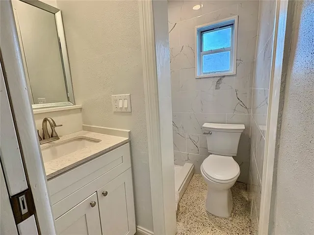 a bathroom with a sink toilet and a mirror