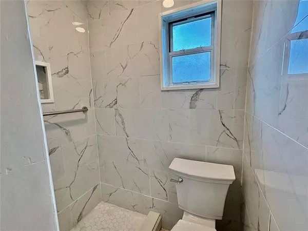 a white toilet sitting next to a shower curtain
