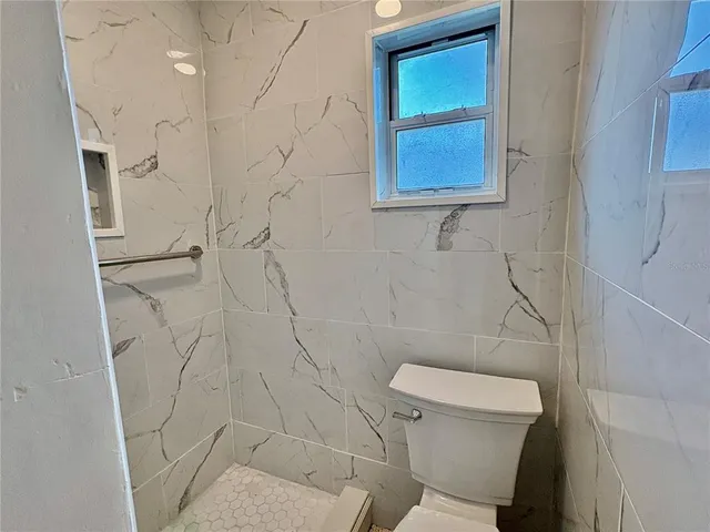 a white toilet sitting next to a shower curtain