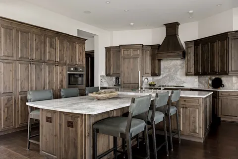 a kitchen with a table chairs sink and cabinets