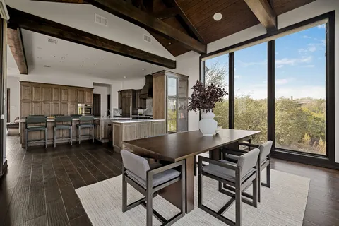 a dining room with furniture and a floor to ceiling window