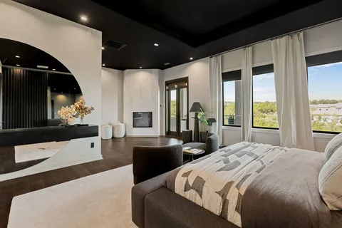 a large bedroom with a large bed and a flat tv screen on dresser