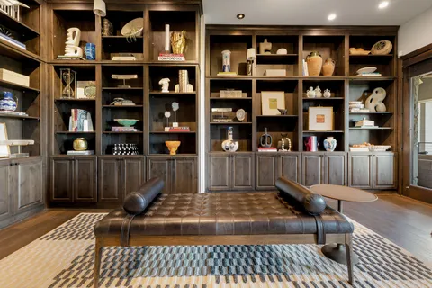 a view of a livingroom with bookshelf and furniture