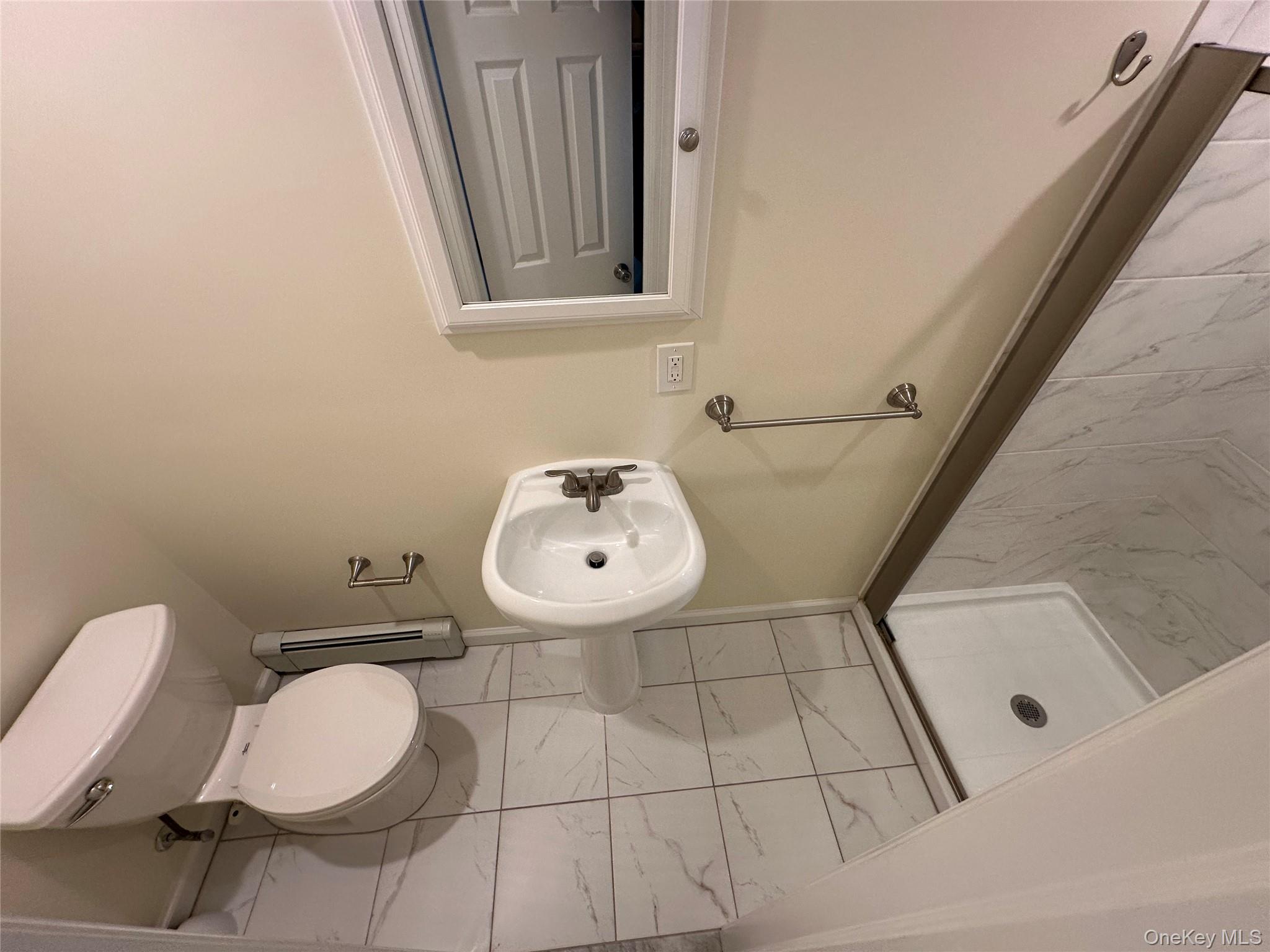 18 West Maple Avenue Suffern, NY 10901 - Photo 16 of 24 Renovated Full bathroom featuring light tile floors, a stall shower, and a baseboard radiator
