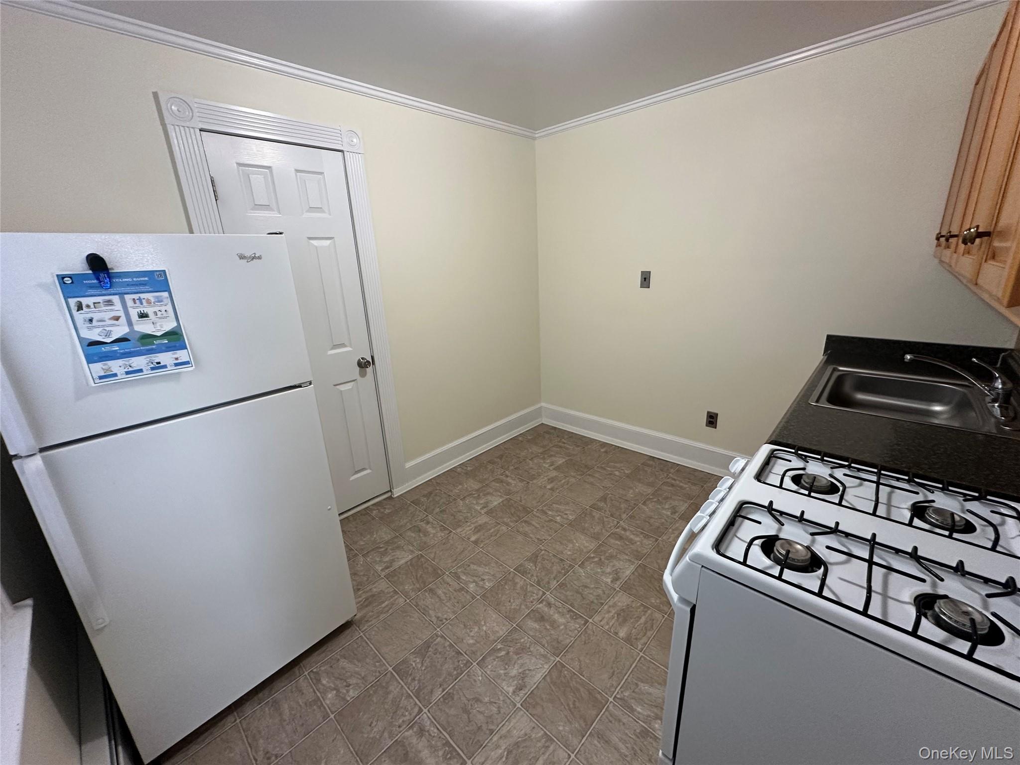 18 West Maple Avenue Suffern, NY 10901 - Photo 6 of 24 Kitchen with white appliances, ornamental molding, and stone finish flooring