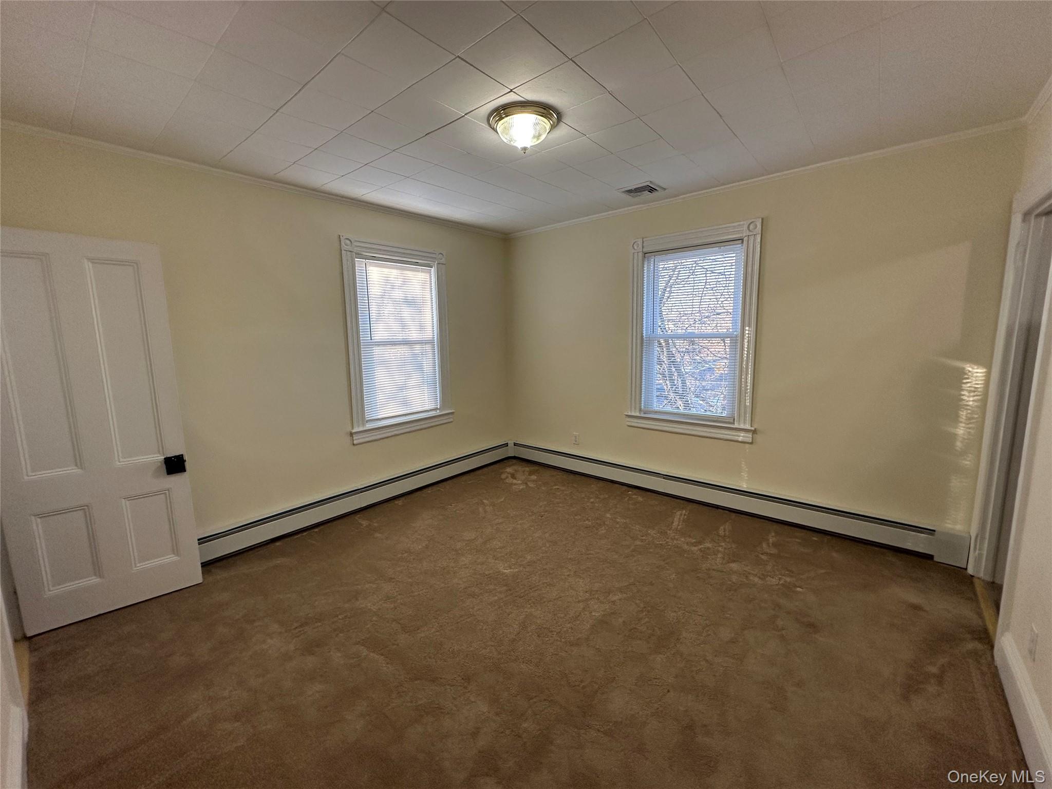 18 West Maple Avenue Suffern, NY 10901 - Photo 7 of 24 Living room with ornamental molding, a baseboard radiator, and dark colored carpet