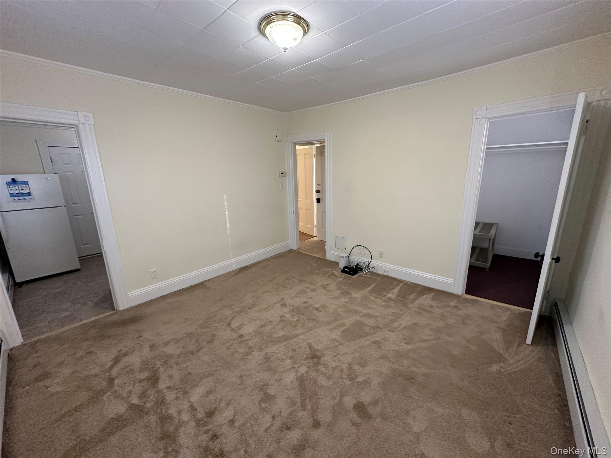 18 West Maple Avenue Suffern, NY 10901 - Photo 8 of 24 Living Room with baseboard heating, carpet, and ornamental molding with Closet