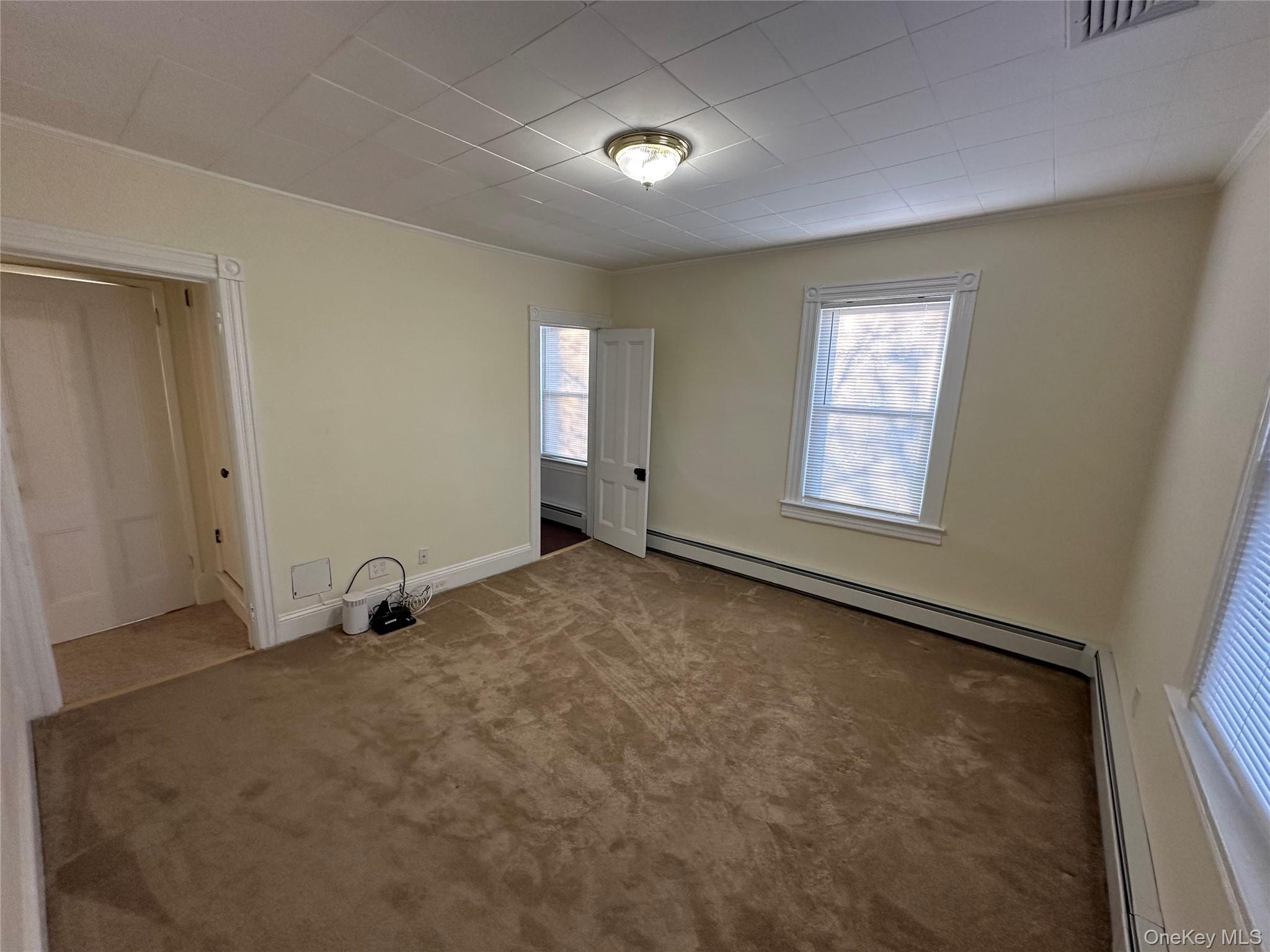 18 West Maple Avenue Suffern, NY 10901 - Photo 10 of 24 Another view with carpet and a baseboard heating unit