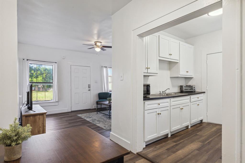 112 West Eighth Street Dallas, TX 75208 - Photo 11 of 34 a open kitchen with granite countertop a stove a sink a window and white cabinets