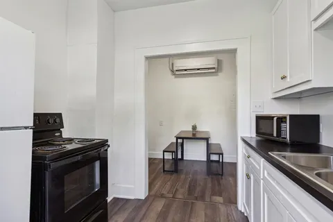a kitchen with granite countertop white cabinets and a sink