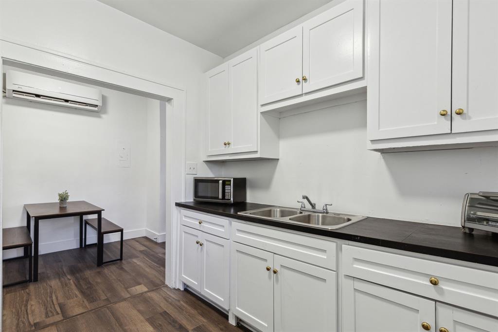 112 West Eighth Street Dallas, TX 75208 - Photo 17 of 34 a kitchen with granite countertop white cabinets and a sink