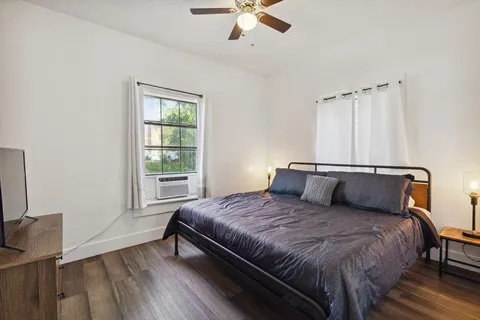 a bedroom with a bed and wooden floor