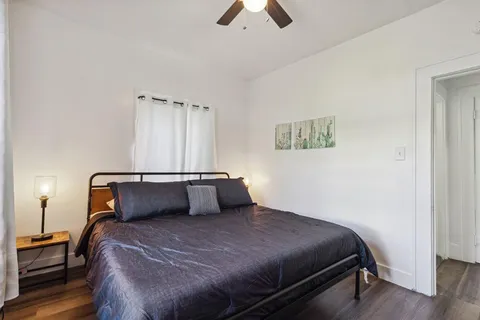 a bedroom with a bed and wooden floor