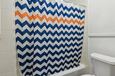 a living room with furniture a flat screen tv and a window