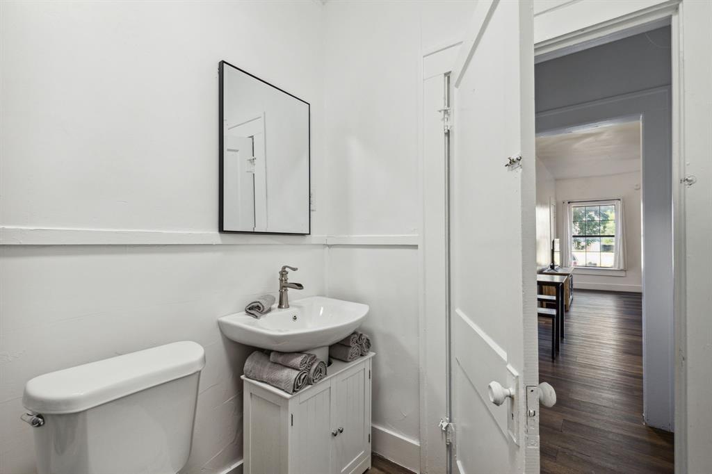 112 West Eighth Street Dallas, TX 75208 - Photo 23 of 34 a bathroom with a sink a toilet and mirror
