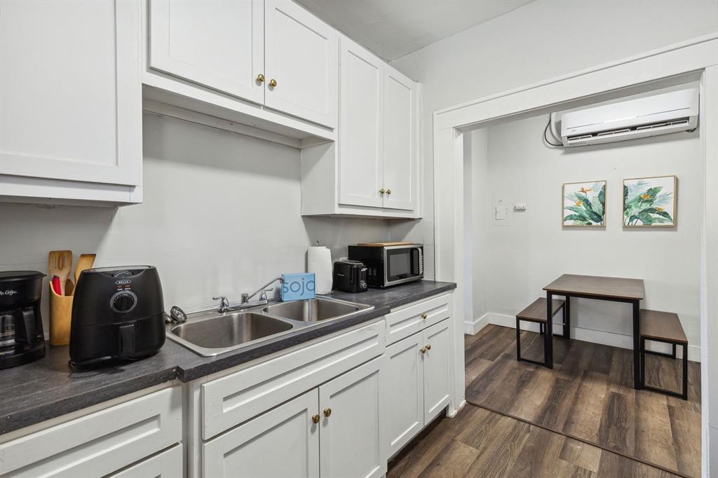 112 West Eighth Street Dallas, TX 75208 - Photo 26 of 34 a kitchen with granite countertop cabinets stainless steel appliances and wooden floor