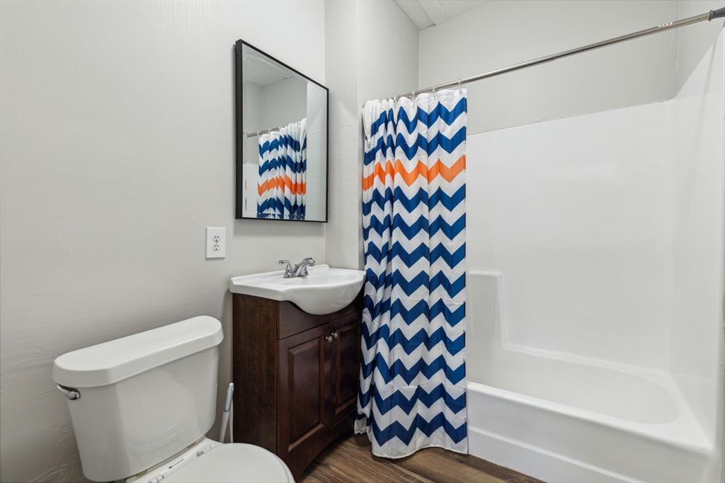 112 West Eighth Street Dallas, TX 75208 - Photo 30 of 34 a bathroom with a toilet sink and shower curtain