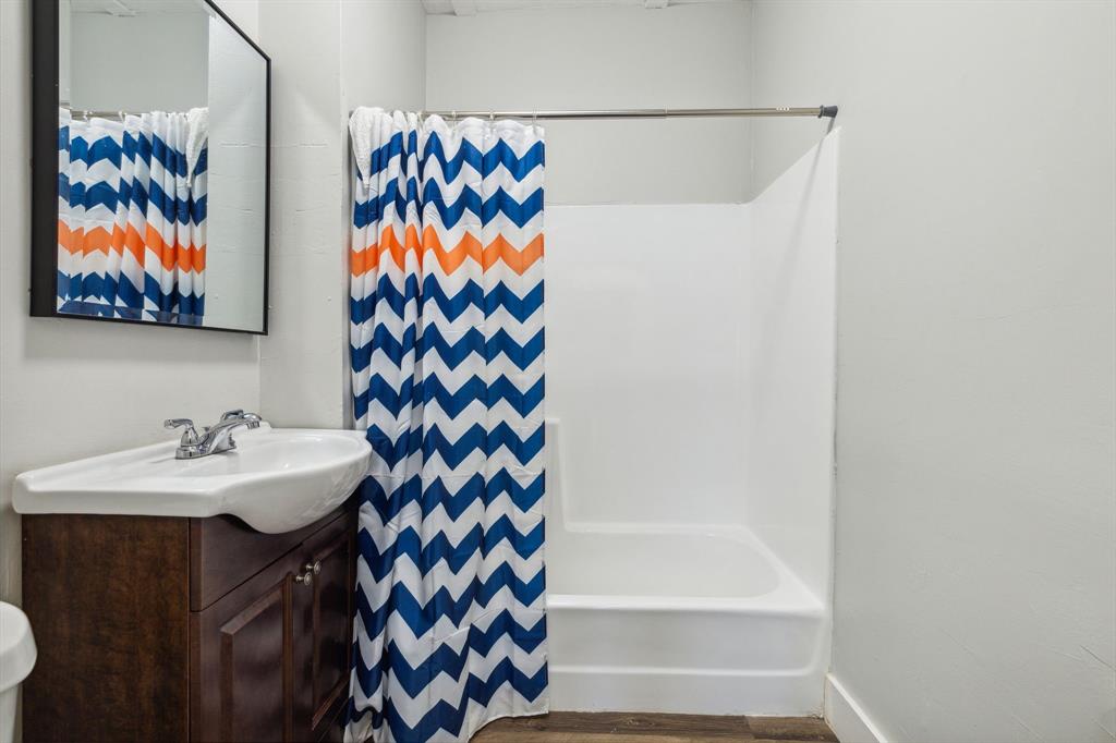 112 West Eighth Street Dallas, TX 75208 - Photo 31 of 34 a bathroom with a sink and a mirror
