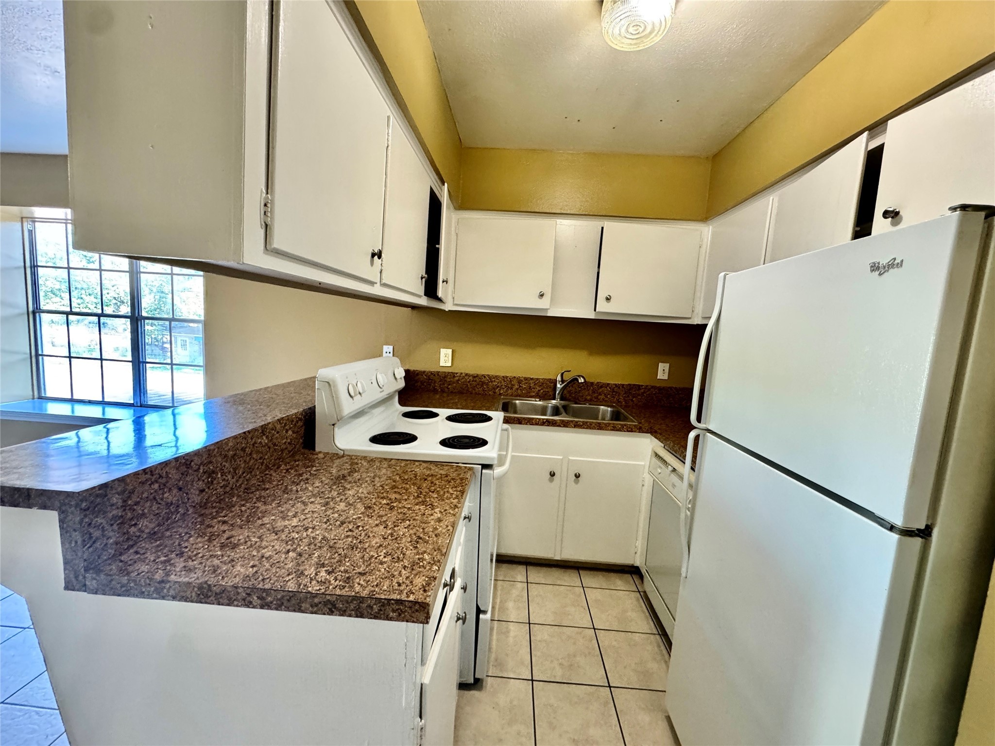 2201 North Grand Boulevard, Unit 2 Pearland, TX 77581 - Photo 8 of 9 a kitchen with a refrigerator a stove a sink dishwasher and cabinets with wooden floor