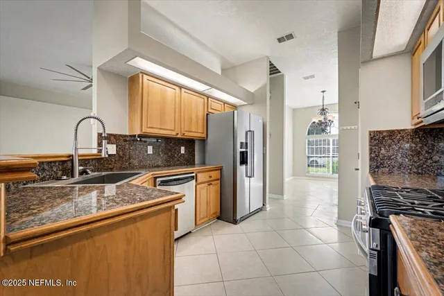 a kitchen with granite countertop a sink stainless steel appliances and cabinets