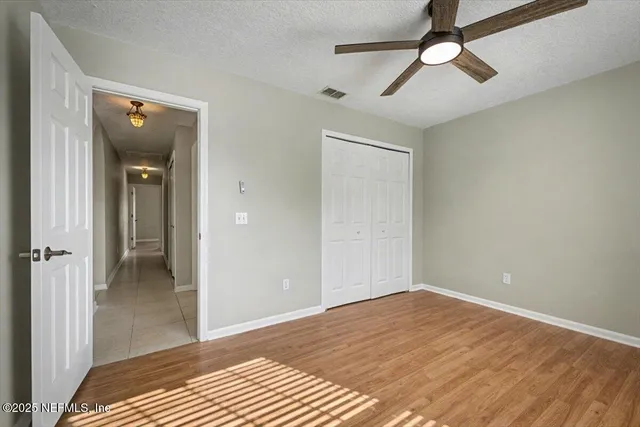 a view of an empty room with wooden floor