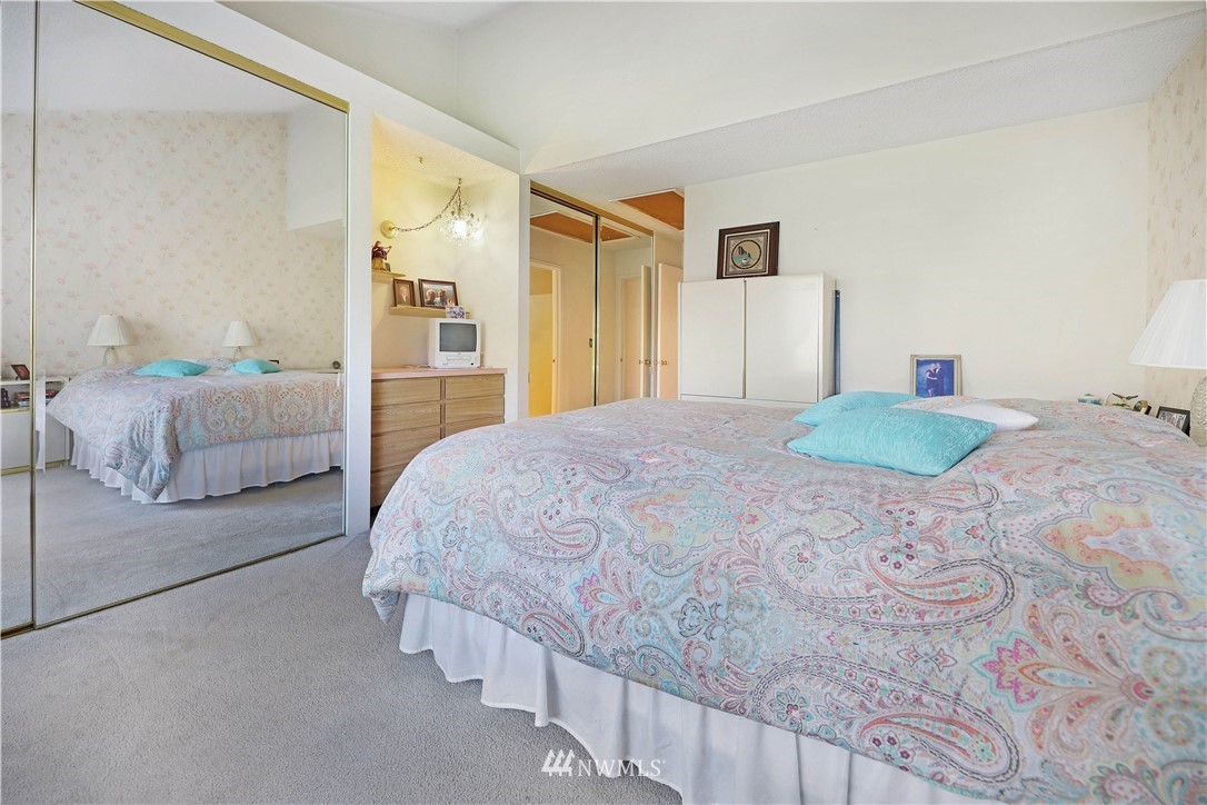 6413 Sand Point Way Northeast Seattle, WA 98115 - Photo 14 of 25 a bedroom with a large bed and a chandelier