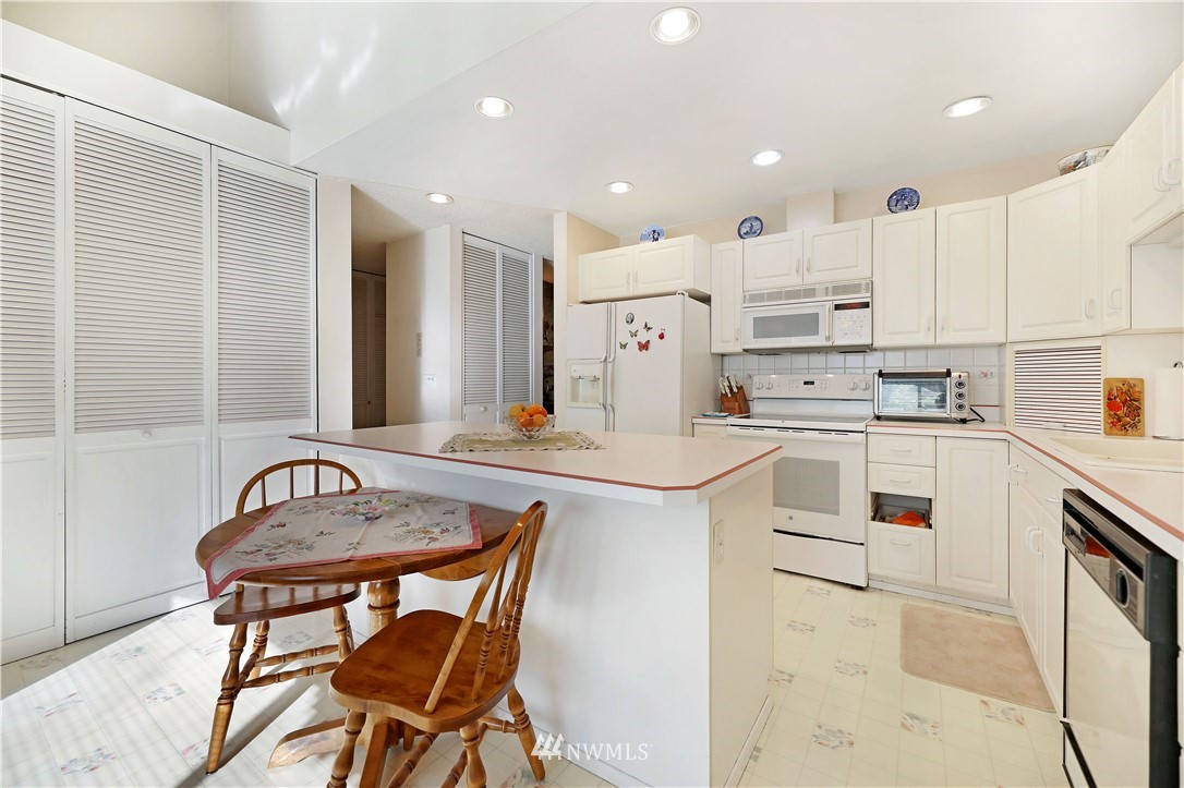 6413 Sand Point Way Northeast Seattle, WA 98115 - Photo 18 of 25 a kitchen with kitchen island a appliances dining table and chairs