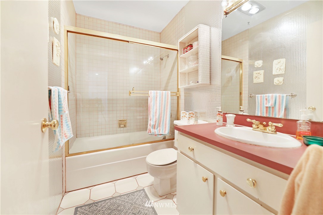 6413 Sand Point Way Northeast Seattle, WA 98115 - Photo 7 of 25 a bathroom with a sink a toilet and a large mirror