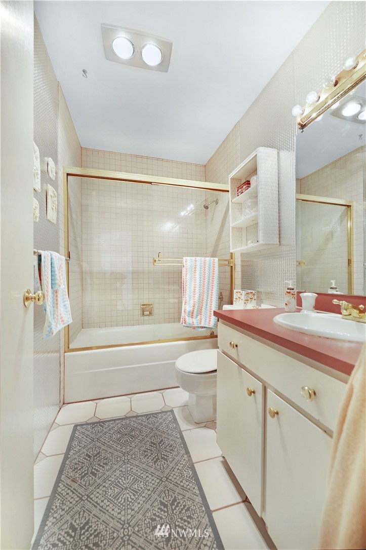 6413 Sand Point Way Northeast Seattle, WA 98115 - Photo 8 of 25 a bathroom with a tub sink and mirror