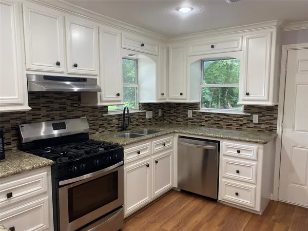 a kitchen with granite countertop white cabinets and appliances
