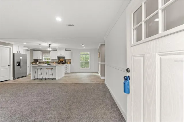 a view of a kitchen with refrigerator and a sink