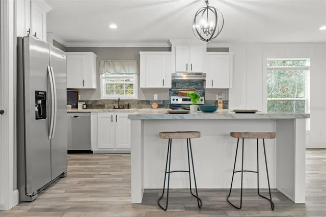 a kitchen with stainless steel appliances a refrigerator sink and cabinets