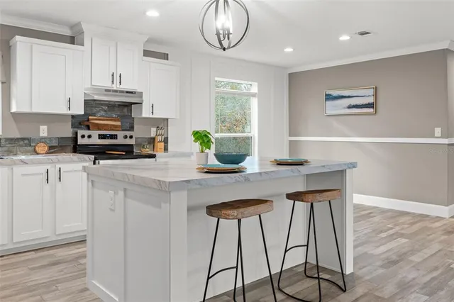 a kitchen with stainless steel appliances granite countertop a stove top oven a sink a counter space and cabinets