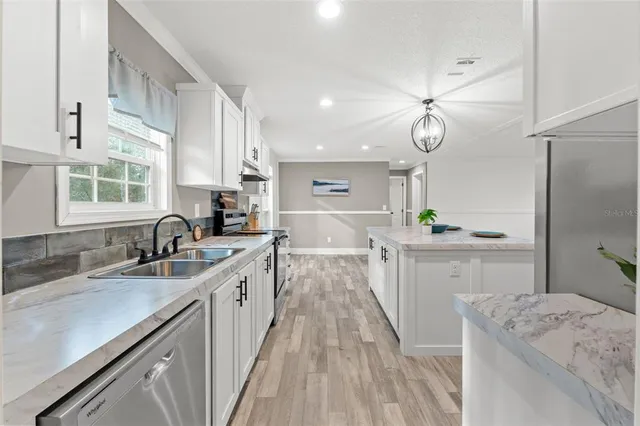 a kitchen with a sink stove cabinets and window